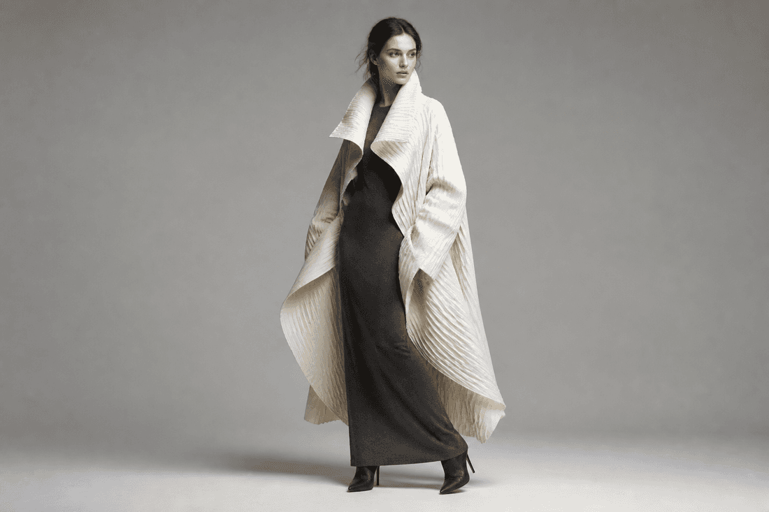 Editorial portrait in a sculptural ivory pleated coat
